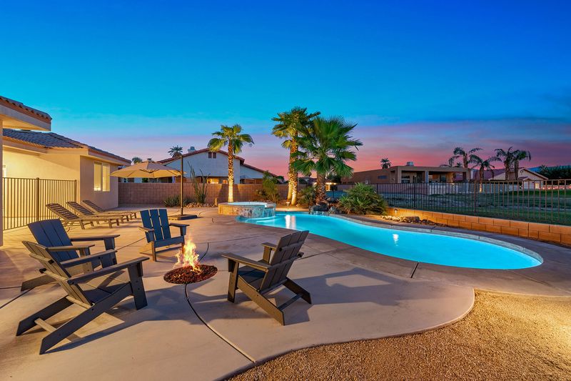 Private pool, fire pit and Adirondack chairs at sunset at Palms Place vacation rental in Indio CA