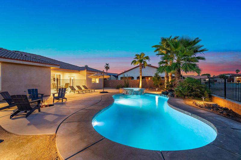 Pool lit at night at Palms Place vacation rental Indio