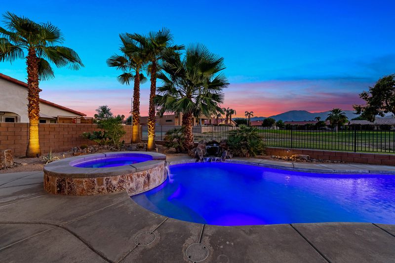 Heated pool and spa at twilight with Santa Rosa mountain views at Palms Place Indio