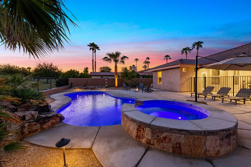 Private spa and hot tub under palm trees at twilight at Palms Place Indio